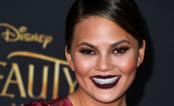 Chrissy Teigen faalt haar borsten in haar jumpsuit te krijgen